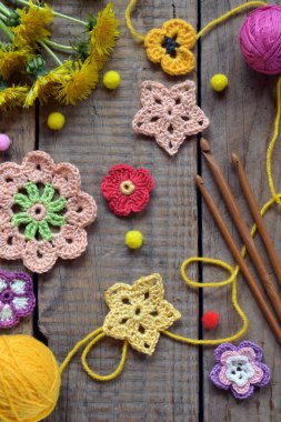 Yünlü ahşap masaya yerleştirilmiş iplik ve karahindiba çiçekleri el yapımı bahar temalı düz yataklar ve el işi dekorasyon projeleri için mükemmel.