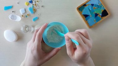 Alçı taşı tozunu suyla karıştırmak ve silikon kalıpta düzenlenmiş renkli cam parçalarının üzerine beyaz bileşik dökerek adım adım el yapımı mozaik bardak altlığı yaratmak.