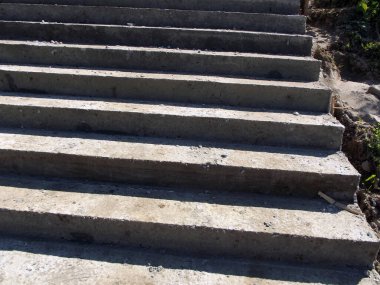 Peyzaj projesinde eğimli konut arazisindeki merdiven inşaatı sırasında döküm dokusu olan sert beton merdiven yüzeyinin yakın görüntüsü