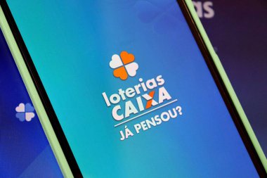 Bahia, Brezilya - 29 Ağustos 2025: Loterias Caixa logosu akıllı telefon ekranında dizüstü bilgisayarın üstünde. Brezilya Piyango konsepti.