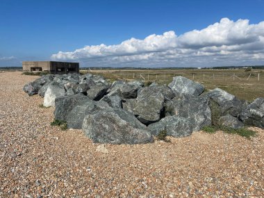Camber Sands, Rye 'da bir tabeladaki ikinci dünya savaşı ilaç kutusu. Açık denizlerden korunmak için önplandaki büyük kayalar da görülebilir.