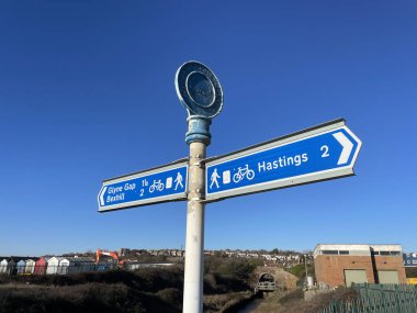 Glyne Gap, Bexhill 'den Hastings.Mileages' e giden bir sahil yolunun bisiklet rotasını ve yürüyüş yolunu gösteren bir işaret. Mavi işaret karşı ve güneşli mavi gökyüzü