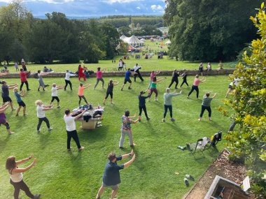 Ragley Hall-Alcester-Warwickshire-İngiltere-26 Ağustos 2023 - Birçok insan kırsal ve festival çadırlarına bakan bir yoga, thai chi dersi alıyor. İnsanlar senkronize olarak silah taşıyorlar. Dikkat, dikkat, dikkat, rahatlama, dinlenme..