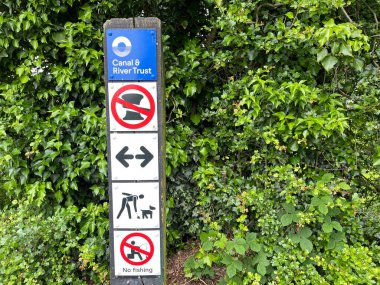 Crick-Northampton-UK - 23 Mayıs 2024 - Kanal yolu üzerindeki işaret direğindeki İşaret ve Semboller, dar tekne kullanıcıları için çeşitli kısıtlamaları ve talimatları göstermektedir. Kanal ve Nehir Vakfı. Arka planda hedge.