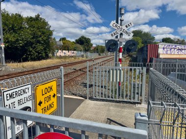 Çeşitli uyarı ve kapı işaretleri olan bir demiryolu yaya geçidi..