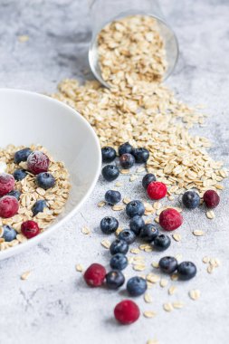 Oatmeal flaking with fresh blueberries, on a concrete background. healthy eating