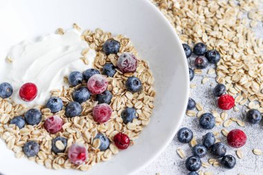 Oatmeal flaking with fresh blueberries, on a concrete background. healthy eating