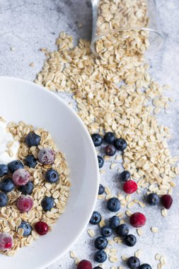 Oatmeal flaking with fresh blueberries, on a concrete background. healthy eating