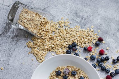 Oatmeal flaking with fresh blueberries, on a concrete background. healthy eating