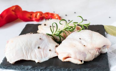 Raw chicken thighs. On a raw background. With various seasonings