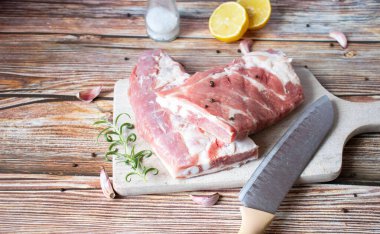 Raw pork ribs with rosemary and black pepper. on a wooden background
