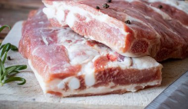 Raw pork ribs with rosemary and black pepper. on a wooden background