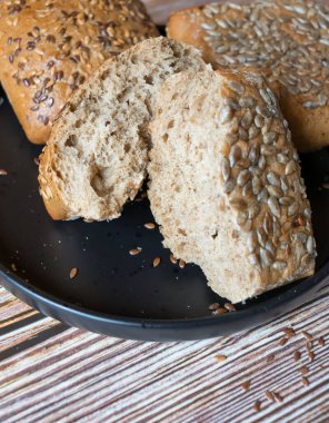 buns with seeds on a daily table, on a rustic wooden background.
