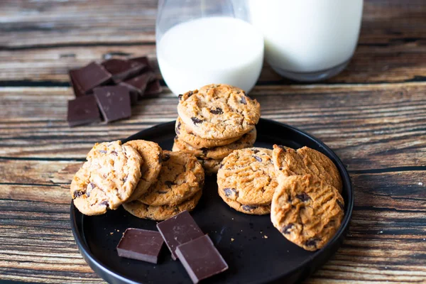 Chocolate cookies with pieces of chocolate on a wooden background
