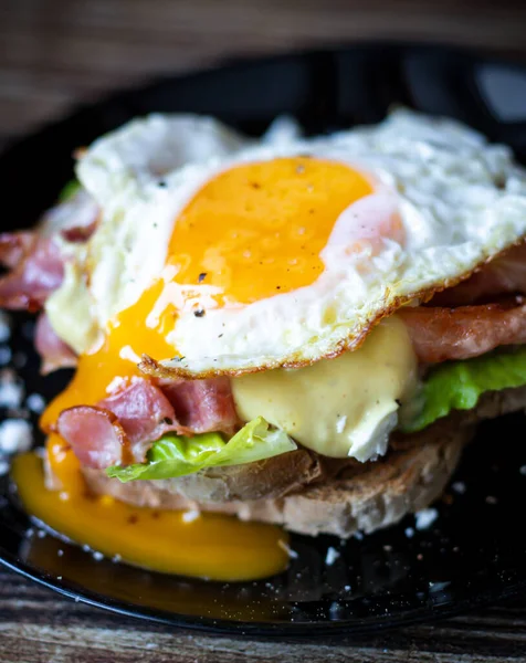 A fresh and healthy toasted sandwich made from fresh vegetables. Sandwich with eggs and bacon.