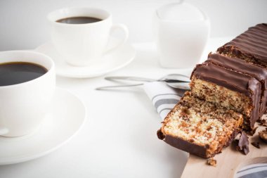 Banana bread with chocolate and milk on a light gray background. Homemade delicious pastries. View from above