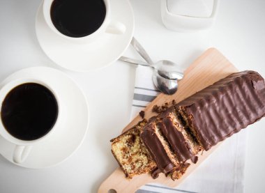 Banana bread with chocolate and milk on a light gray background. Homemade delicious pastries. View from above