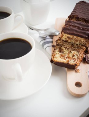 Banana bread with chocolate and milk on a light gray background. Homemade delicious pastries. View from above
