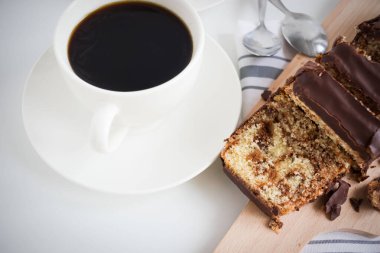 Banana bread with chocolate and milk on a light gray background. Homemade delicious pastries. View from above