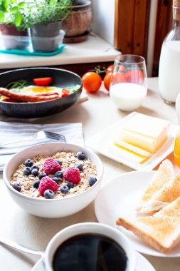 Kahvaltıda. Kızarmış yumurta, yulaf ezmesi, kahve, böğürtlen. Günaydın..