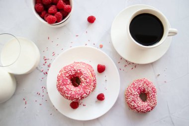 Kahve ve sütlü çörek. Pembe şekerli donut. 