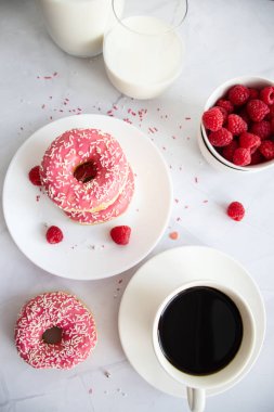 Kahve ve sütlü çörek. Pembe şekerli donut. 