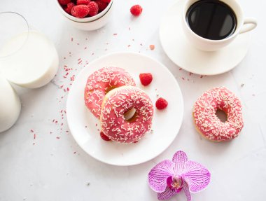 Kahve ve sütlü çörek. Pembe şekerli donut. 