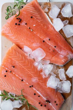 Tahta kesme tahtasında çiğ somon filetosu. Beyaz bir arkaplanda.