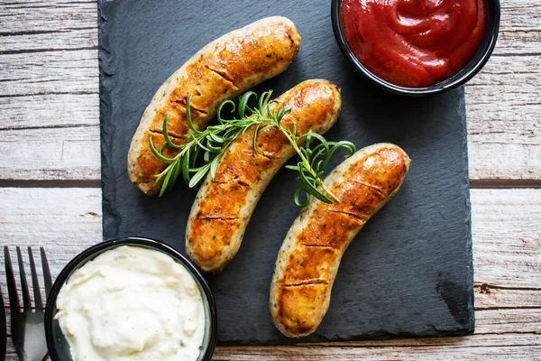 Ahşap arka planda ev yapımı kızarmış sosis. Soslu olsun. Öğle yemeği