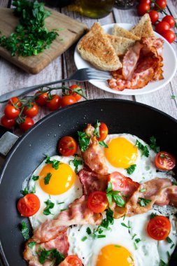 Pastırmalı yumurta ve taze domates. Ahşap bir arka planda