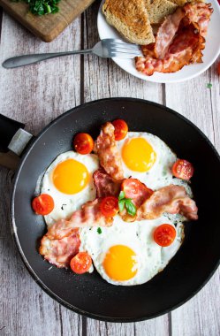 Pastırmalı yumurta ve taze domates. Ahşap bir arka planda