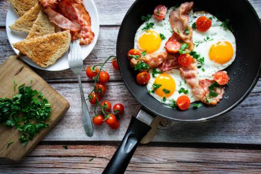 Pastırmalı yumurta ve taze domates. Ahşap bir arka planda