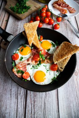 Pastırmalı yumurta ve taze domates. Ahşap bir arka planda