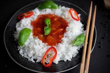 Tatlı ve ekşi soslu pilav. Akşam yemeği. Siyah bir arkaplanda