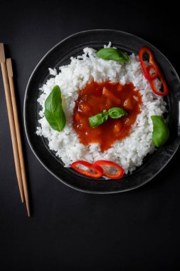 Tatlı ve ekşi soslu pilav. Akşam yemeği. Siyah bir arkaplanda