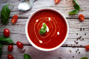 Beyaz kasede taze domates çorbası. Ahşap bir arka planda