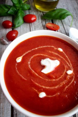 Beyaz kasede taze domates çorbası. Ahşap bir arka planda