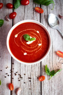 Beyaz kasede taze domates çorbası. Ahşap bir arka planda