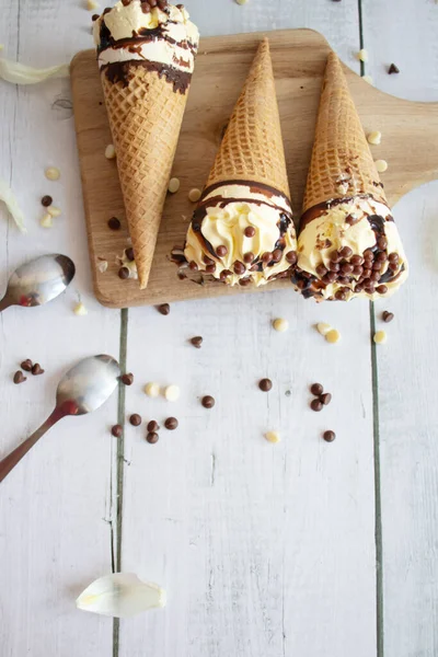 stock image Vanilla chocolate ice cream cone. On a white wooden background. Sweets