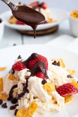 Çilekli dondurma ve çikolatalı çiseleme. Ahşap bir arka planda. Tatlı.