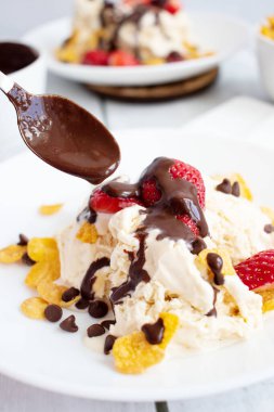 Çilekli dondurma ve çikolatalı çiseleme. Ahşap bir arka planda. Tatlı.