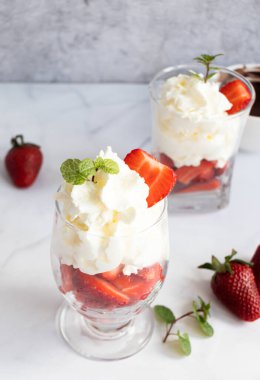 Krem şanti ve taze çilekten tatlı. hafif bir arkaplanda