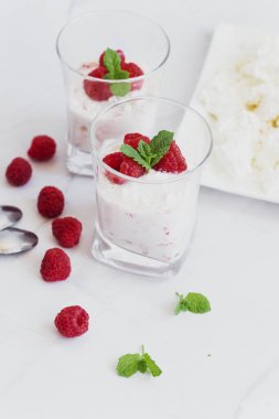 Yoğurt ve ahududulu tatlı. Lezzetli. Beyaz bir arkaplanda