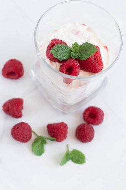 Yoğurt ve ahududulu tatlı. Lezzetli. Beyaz bir arkaplanda