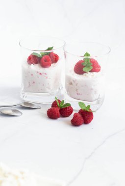 Yoğurt ve ahududulu tatlı. Lezzetli. Beyaz bir arkaplanda