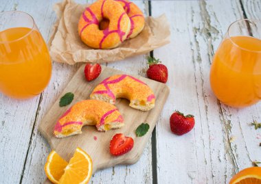 Çilekli taze çörek ve portakal suyu. beyaz ahşap arka planda.
