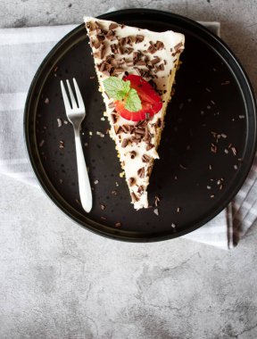 Kahve ve kek, çikolatalı ve siyah tabakta çilekli. Tatlı tatlı