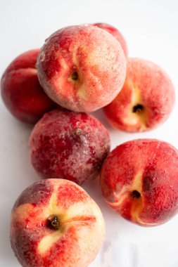 Beyaz arka planda olgun şeftaliler. Üst Manzara. Kapat. Beyaz arka planda bir kasede taze şeftali.