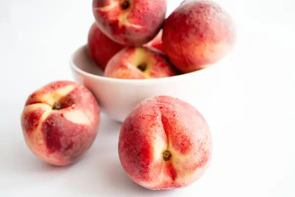 stock image ripe peaches on a white background. top view. close up. fresh peaches in a bowl on a white background.