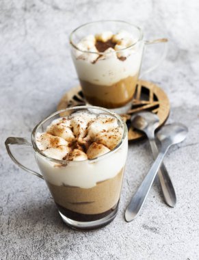 Kahve tatlısı. Gri bir arkaplanda. Tiramisu fincanda.